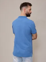 Remera polo negra de piqué de algodón con cuello clásico y tapeta de dos botones. Presenta un pequeño logo bordado en el pecho.