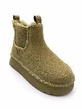 Pantubotas de gamuza color tostado, con plataforma gruesa dentada, elásticos laterales y forro interno de corderito sintético.