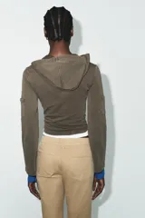 Sudadera de algodón color gris oscuro con capucha, manga larga y detalle de texto con aplicación de brillos en el pecho. Presenta un diseño con bolsillos laterales en las mangas y bajo recto.