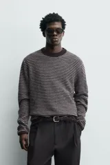 Jersey de punto con diseño de rayas horizontales en tonos marrón y gris, de corte relajado, cuello redondo y manga larga con terminaciones en rib.
