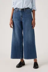 Jeans de mezclilla azul con diseño wide leg, tiro medio y corte al tobillo.