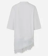 Remera de algodón corte oversized, color blanco, con cuello redondo, mangas cortas amplias y ruedo asimétrico con detalle de encaje aplicado.