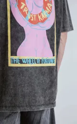 Remera negra con efecto nevado, corte oversize, mangas cortas y cuello redondo. Estampado en la espalda con diseño de una figura femenina y la frase 'Chill Bitch Trust Karma - The Wheel of Fortune'.