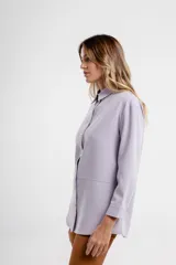 Camisa magenta de corte holgado con cuello clásico y cierre frontal con botones.