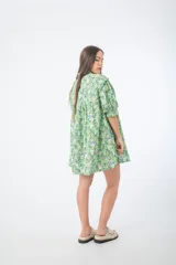 Vestido corto verde con estampado floral, cuello alto, mangas cortas abullonadas y corte holgado.