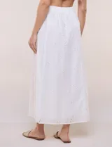 Falda maxi de algodón blanco con diseño de broderie, tiro alto con pretina elástica y corte evasé.