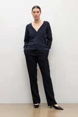 Cardigan negro con escote en V, manga larga y cierre frontal con botones pequeños. Presenta puños acanalados con detalle de botones decorativos.
