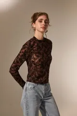 Top de manga larga con cuello alto, confeccionado en tejido semitransparente con estampado tipo paisley en relieve.