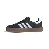 Zapatillas Adidas Samba de cuero negro con las tres tiras blancas y suela de goma marrón con plataforma.
