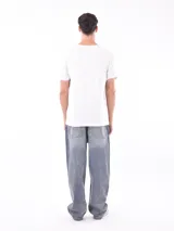 Remera de manga corta color gris topo, corte slim, con cuello redondo y un estampado gráfico en el pecho que combina texto manuscrito con un diseño abstracto en tonos oscuros.