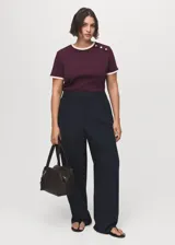 Pantalón de vestir de tiro bajo y diseño wide leg color azul marino, con pinzas en la parte delantera y bolsillos laterales.