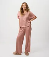 Pijama americano de satén color rosa viejo, compuesto por una camisa de manga corta con cuello solapa y botones frontales, y un pantalón largo de corte recto con cintura elastizada.