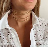 Gargantilla dorada de tres líneas finas.