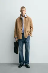 Chaqueta relaxed fit de piel con acabado serraje en color tostado, con cuello de solapa combinado a contraste, bolsillos de plastrón con solapa en la cadera y cierre frontal de botonadura.