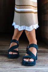Sandalias de cuero color negro, de taco medio y cómodo, con tiras cruzadas y hebilla lateral ajustable.