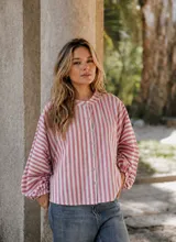 Camisa oversize de lino con estampado de rayas verticales en tonos rosado y blanco. Presenta cuello redondo, cierre frontal con botones y mangas largas abullonadas con puños elásticos.