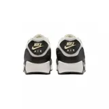 Championes Nike Air Max 90 con diseño clásico, combinando paneles de cuero blanco, beige y detalles en negro con textura de reptil. Cuenta con la icónica unidad de aire visible en el talón y suela de goma resistente.