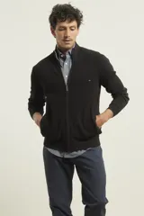 Cardigan de punto color azul marino, con cierre frontal de metal y cuello alto. Presenta tejido de punto fantasía y bolsillos laterales.