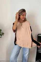 Remerón de manga corta, color beige claro, con bloques de color negro en las mangas. Presenta cuello redondo y un calce holgado.