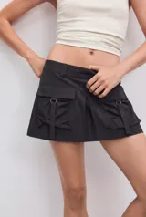 Falda pantalón satinada de tiro medio y color negro, con bolsillos cargo de plastrón con solapa, pliegues decorativos en el delantero y cierre lateral con cremallera oculta.