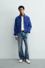 Sobrecamisa regular fit de Zara, confeccionada en pana de algodón color azul con efecto lavado. Cuenta con cuello solapa, manga larga con puño y botón a presión, bolsillos frontales de plastrón con solapa y cierre de cremallera.