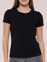 Remera básica de corte al cuerpo con textura acanalada, cuello redondo y mangas cortas. Presenta una pequeña placa metálica decorativa en el borde inferior.