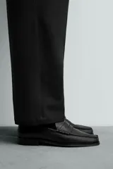 Mocasín de vestir fabricado en piel color marrón oscuro, con detalle de antifaz en el empeine, plantilla de piel y suela a contraste con ligero tacón.