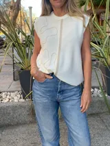 Top tejido color crema, con cuello redondo y diseño abstracto en color beige.