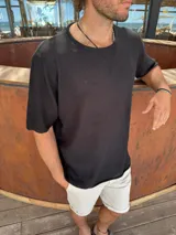 Buzo negro de tejido calado con mangas cortas y cuello redondo.