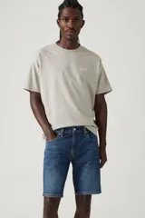 Bermuda de jean de calce slim, color azul medio, con bolsillos delanteros y traseros.