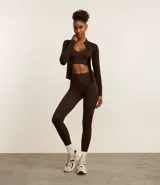 Campera deportiva de corte ajustado, confeccionada en tejido seamless de poliamida y elastano. Presenta cuello alto, cierre frontal con cremallera y textura acanalada.