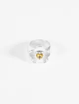 Anillo plateado con forma de flor y piedra amarilla en el centro.