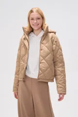 Campera acolchada color beige con diseño de rombos, cuello alto, capucha desmontable y cierre frontal con botones a presión.