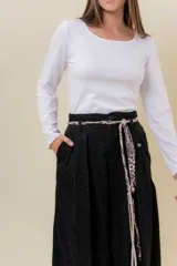 Pantalón wide leg de tiro alto en color negro, con diseño de pinzas delanteras que aportan volumen y caída fluida. Incluye bolsillos laterales y un lazo desmontable en la cintura que combina cordón con cinta de estampado animal print.