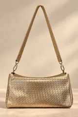Cartera de mano Pecari modelo Bea, confeccionada en cuero vacuno con textura tejida color dorado. Presenta solapa frontal con broche imantado y placa metálica con el logo de la marca, además de una correa larga para el hombro.