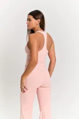 Conjunto deportivo de dos piezas en color rosa pastel. Incluye un top de escote redondo con espalda estilo nadadora y logo estampado en el frente, y una calza de tiro alto con costuras reforzadas a tono.