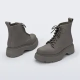 Botas tipo borceguí de la marca Melissa, confeccionadas en material sintético con acabado mate. Presentan diseño de caña media con cordones al tono, suela track de plataforma robusta y tirador en la parte trasera.