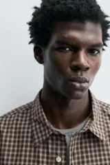 Camisa relaxed fit de algodón con estampado de cuadros en tonos marrón y beige. Cuenta con cuello solapa, manga larga con puño abotonado, bolsillo plastrón en el pecho y cierre frontal de botonadura.