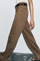 Pantalón de jean color marrón, de tiro alto, corte wide leg y relaxed fit. Cuenta con bolsillos delanteros y traseros, trabillas en la cintura, cierre frontal con cremallera, botón interior y gancho metálico.