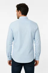 Camisa de lino y algodón color blanco, con cuello camisero, manga larga y cierre frontal de botones.
