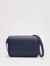 Cartera bandolera Tommy Jeans de color azul marino, de diseño estructurado con acabado liso, solapa frontal con cierre magnético y parche con el logo de la marca grabado en la parte delantera. Cuenta con correa ajustable para el hombro.