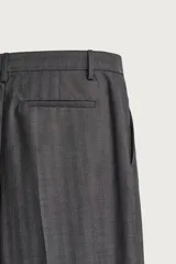Pantalón de vestir gris con diseño de rayas sutiles, de corte relaxed fit, con pinzas delanteras y trabillas para cinturón.