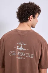 Remera de algodón color marrón con efecto lavado, corte oversize y estampa pequeña en el pecho.