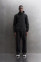 Campera canguro de Zara Athleticz, modelo relaxed fit, confeccionada en tejido técnico compacto elástico con mezcla de algodón en color azul marino. Cuenta con cuello subido con capucha, manga larga con bolsillo lateral con cierre, bolsillos frontales con cierre y acabado termofijado, cierre frontal de doble dirección y logo estampado en el bajo.