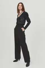 Pantalón negro de vestir de tiro alto, corte ancho y pierna recta.