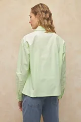 Camisa blanca de algodón con cuello clásico y mangas largas. Detalle de tachas plateadas en el cuello.