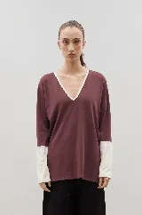 Remera de algodón color bordó con escote en V, puños y detalles en color crema. Presenta un diseño de manga larga con tajos laterales.