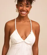 Mono largo blanco de sarga con escote en pico, tirantes finos, lazo en la espalda y cierre con cremallera.