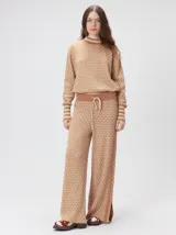 Pantalón de tejido jacquard con textura geométrica en tonos tostado y beige, de tiro medio, cintura elástica con cordón de ajuste y pierna ancha.