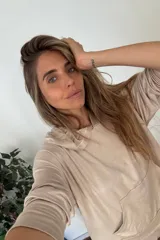 Canguro holgado color beige, con capucha y bolsillo canguro frontal.